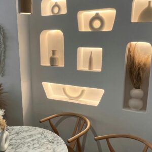 Stylish seating with illuminated decorative wall niches in a cozy setting.