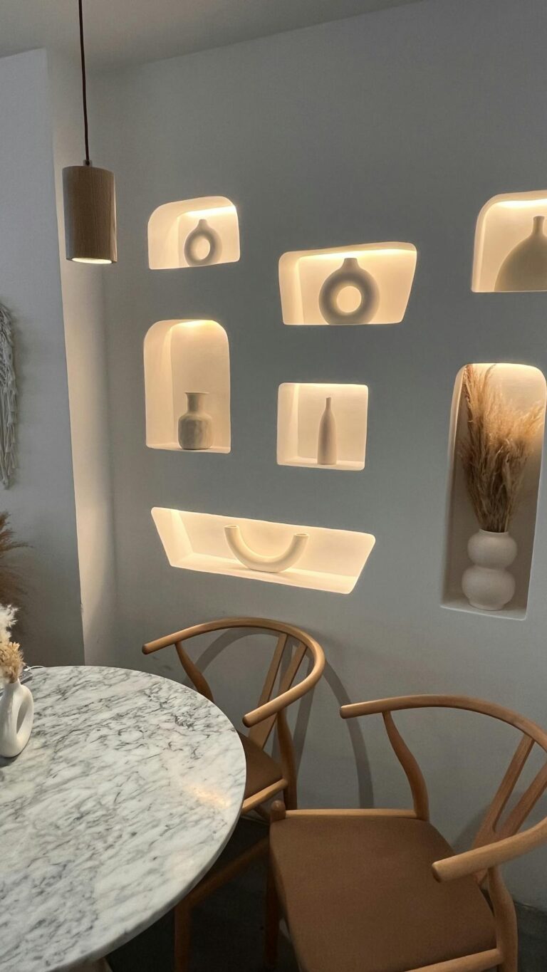 Stylish seating with illuminated decorative wall niches in a cozy setting.